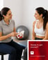 PT points to a pelvis model while speaking to a patient about pelvic health.