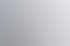 Zwei Männer lächeln, während sie gemeinsam an einem Desktop-Computer arbeiten, einer sitzt am Bildschirm, der andere steht.