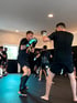 Zwei Männer im Boxtraining in Leipzig mit Handschuhen und Schienbeinschonern in dem Kampfiq Studio.