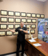 Dr. Currie pointing to a wall of medical certifications at Consider Health clinic in Conway, AR, showcasing expertise in chiropractic and functional medicine.