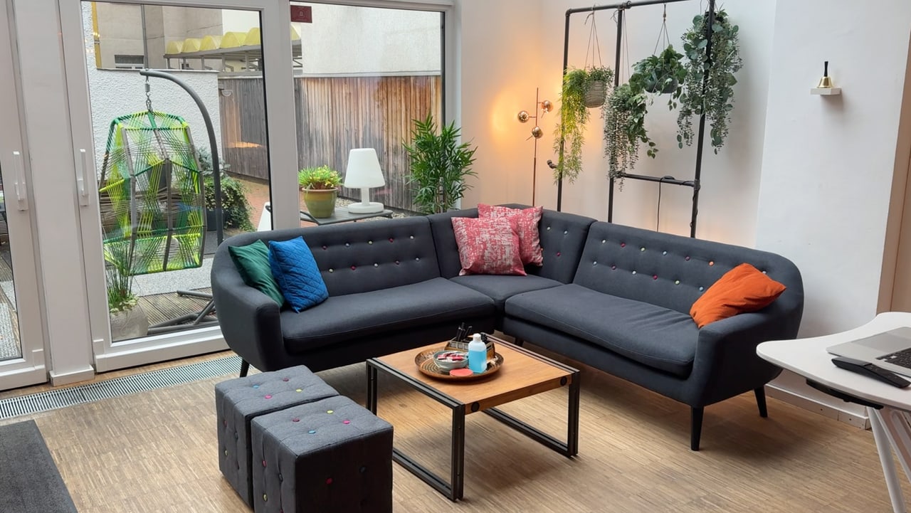 Lounge-Ecke mit Sofa vor großen Fenstern in der Heldraumstation