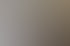 Moderne Kraftgeräte in einem hellen Fitnessstudio mit dunklem Holzboden und großen Fenstern im Hintergrund.
