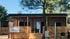 Ein Holzmobilheim mit Veranda und der Aufschrift "3V HOLIDAY RESORT Villa Prosecco" an einem Baum. 