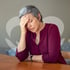 Woman with short hair rests her head, seeking relief from menopause symptoms.
