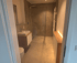 Modernes Badezimmer mit begehbarer Dusche, Waschbecken auf Holzunterschrank und LED-Beleuchtung unter einem Schrank.