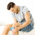 Man applying ice pack to knee, showing work injury recovery.