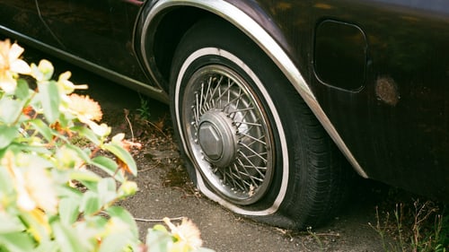 Flat car tire at the roadside, the moment that decides how far you can drive on a spare tire in Normal, IL