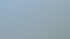 Mann installiert oder reinigt Solarpaneele auf einem Hausdach unter blauem Himmel.