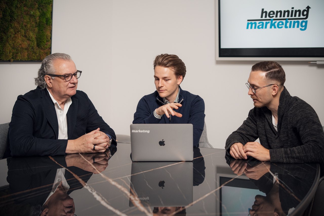 Berater von Henning Marketing erklärt einem Pflegedienst-Inhaber am Laptop die Auswertung seiner Kampagne