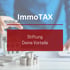 Eine Person hält einen Stift über ein Modellhaus, mit den Texten "ImmoTAX" und "Stiftung gründen".