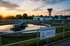 Kläranlage bei Sonnenuntergang mit "WASSERVERSORGUNG" Schild, Wasserturm und Reinigungsbecken - Software-KRITIS Notfall- und Krisenmanager (NKM®).
