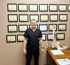 Dr. Currie standing in front of a wall of certifications at Consider Health clinic, showcasing expertise in functional and integrative medicine in Conway, AR.