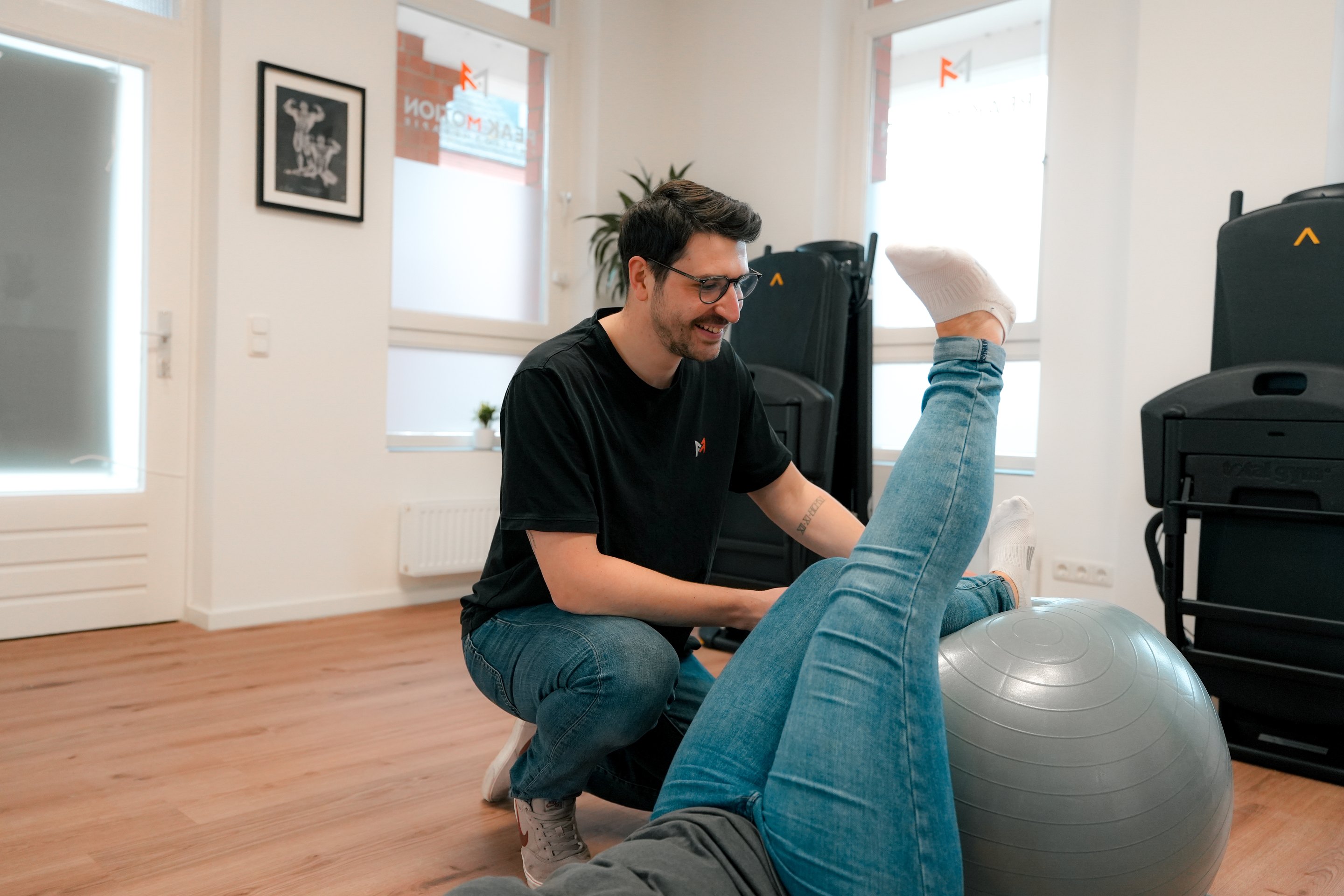 Therapeut bei Peak Motion arbeitet mit einem Patienten an der Beweglichkeit des Beins