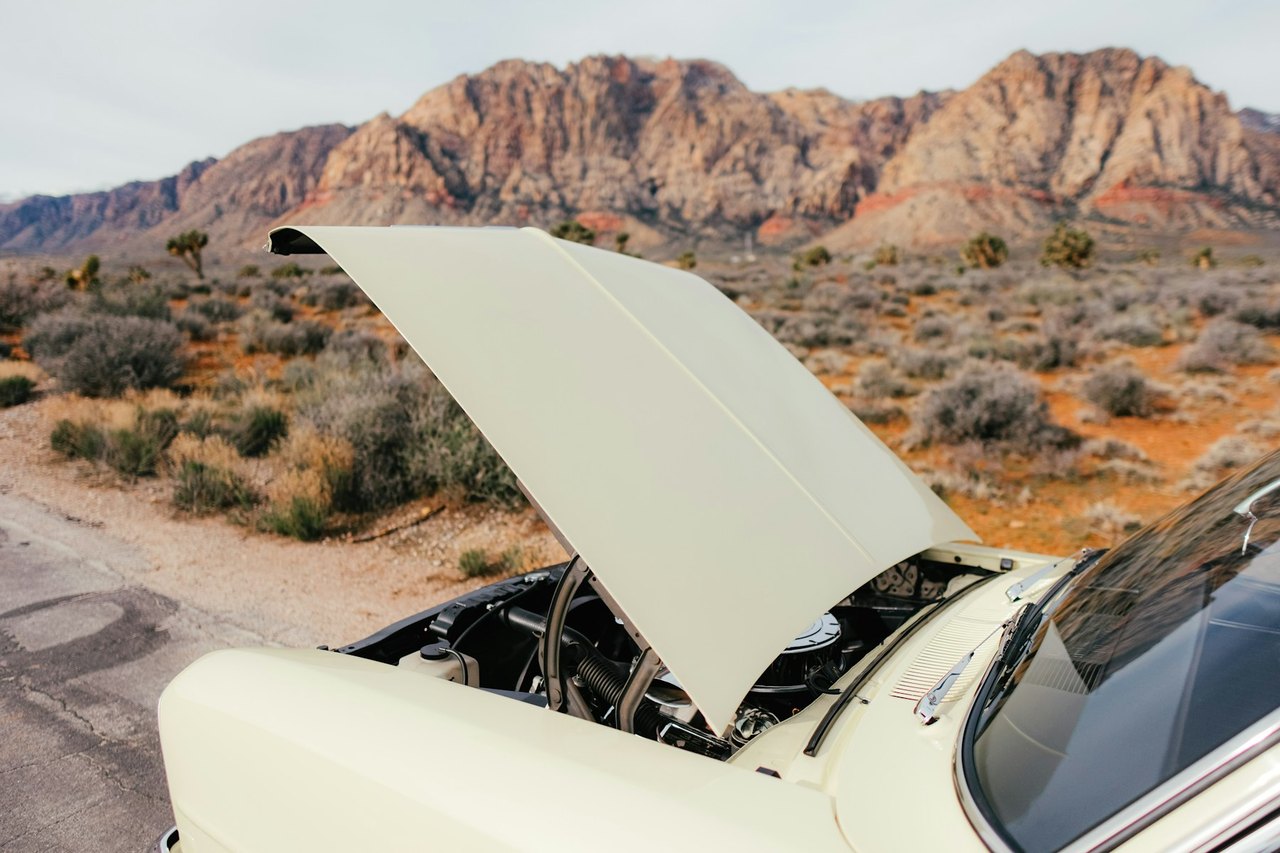 Car overheating with the hood raised on an open roadside in the heat, the kind of summer breakdown Hanford drivers face
