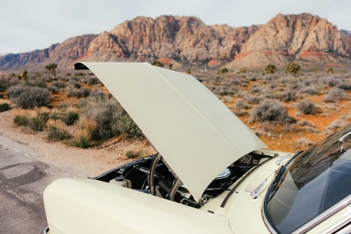 Car overheating with the hood raised on an open roadside in the heat, the kind of summer breakdown Hanford drivers face