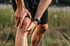 Person clutches knee, showing discomfort from knee pain.