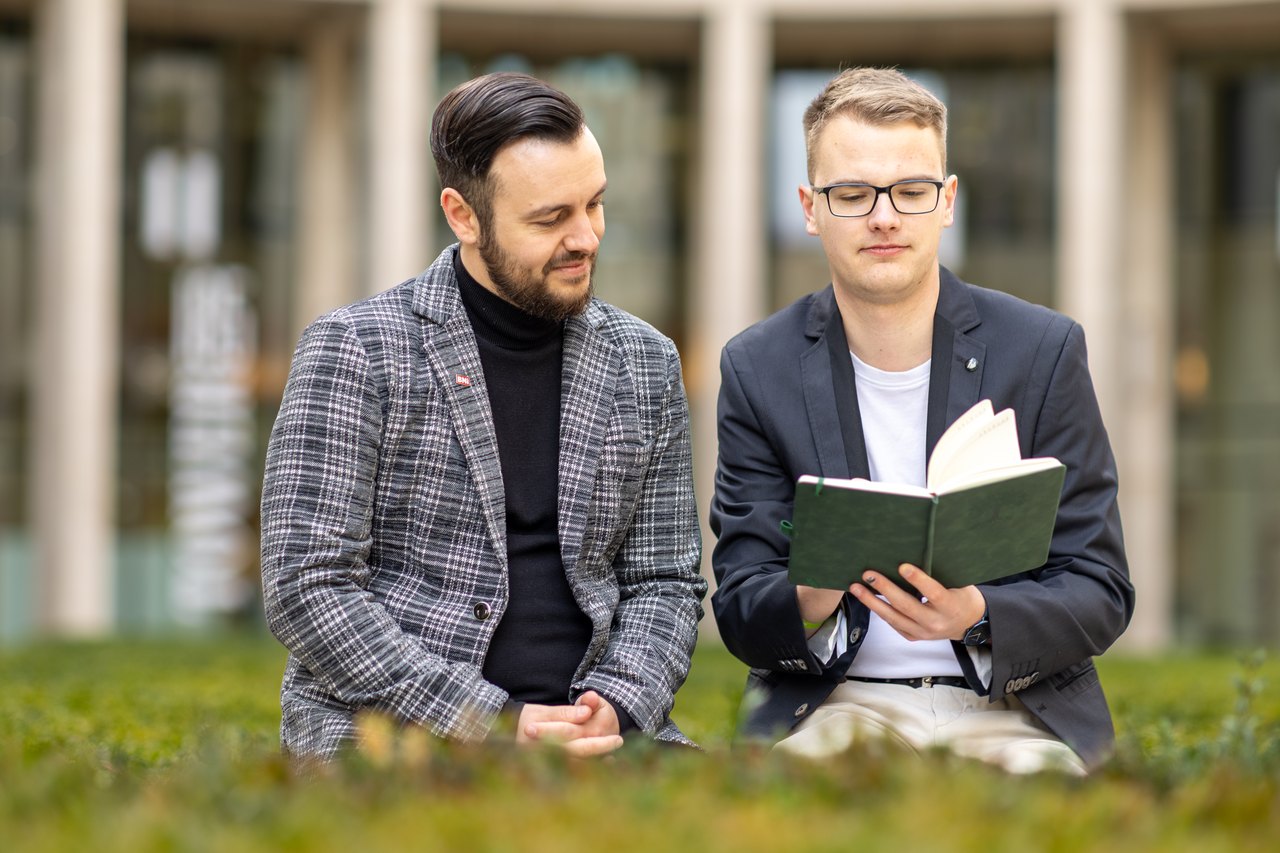 Lukas Wolf und Felix Mauersberger von der Visual Storytellers GbR Leipzig planen mit einem Notizbuch das nächste Kundenprojekt. 