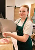 Azubi im Verkauf beim Aufschneiden von Wurst in Körners Hofladen