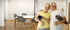 Smiling senior couple holding yoga mats and water bottles, standing together indoors.
