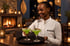 Staff member serving cocktails by the fireplace at Five Volcanoes Boutique Hotel