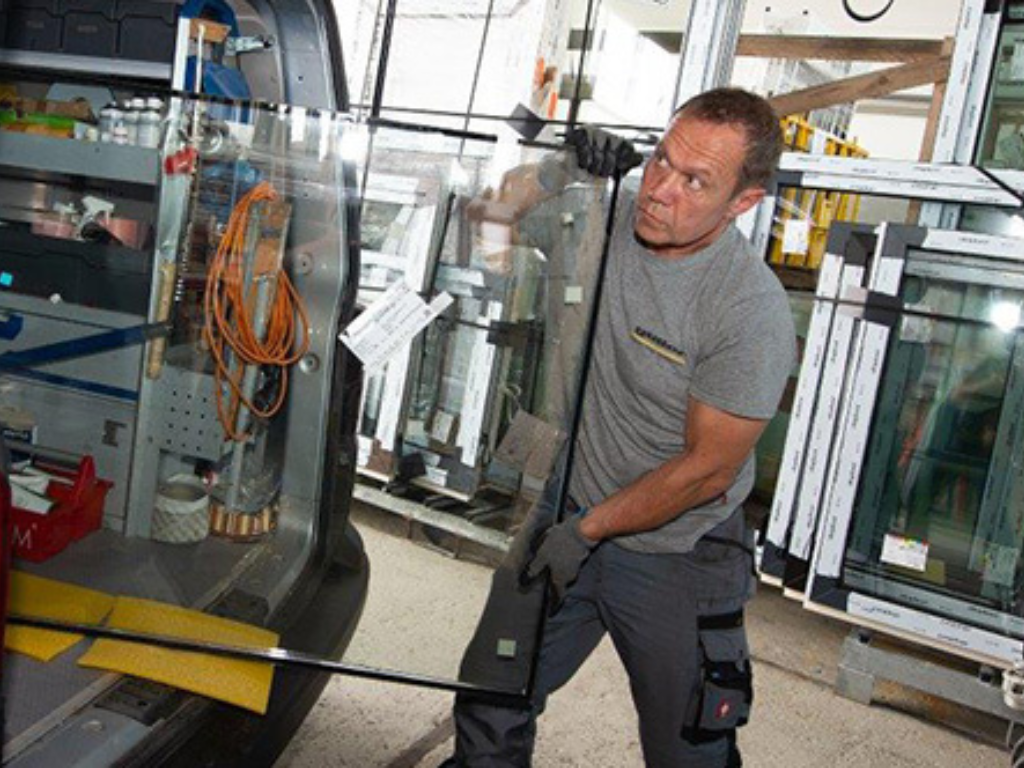 Monteur belädt den Transporter mit Fenstern