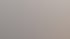 Eine lächelnde Frau telefoniert im Büro vor einem Aktenregal und blättert in Unterlagen auf ihrem Schreibtisch.
