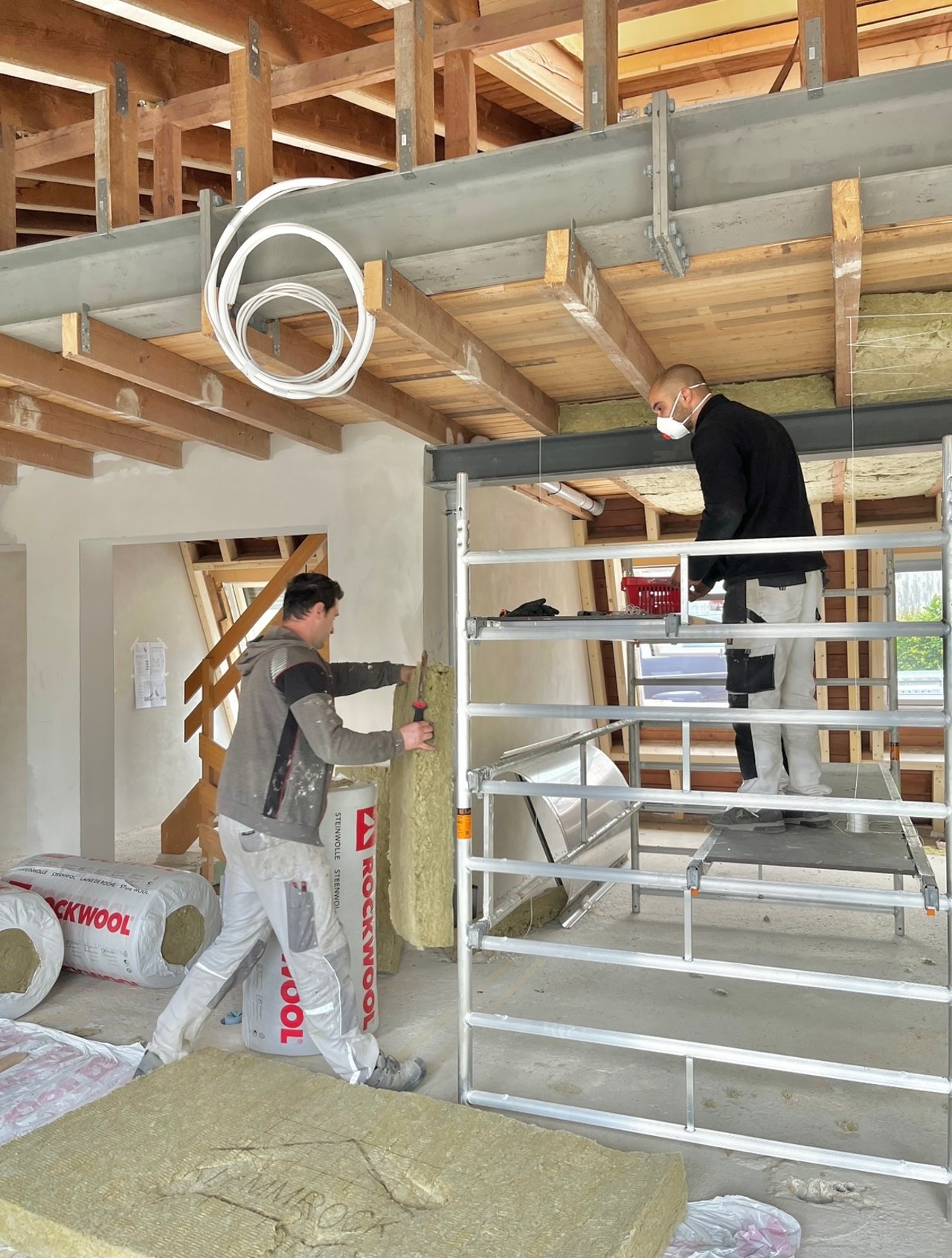 Kollegen von K&G Bauunternehmen bei Dämmarbeiten im Innenausbau