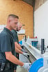 Zwei Mitarbeiter bedienen konzentriert eine industrielle Blechbiegemaschine in einer Werkstatt.
