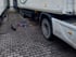 Weißer LKW-Auflieger steht auf Pflastersteinen neben einem Werkzeugkasten und ausgelegtem Werkzeug für Reparaturarbeiten.