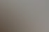 Künstleratelier mit vielen bunten abstrakten Gemälden an einer weißen Wand und einem Arbeitstisch.