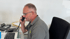 Mann mit Brille telefoniert am Schreibtisch mit einem schwarzen Telefonhörer.