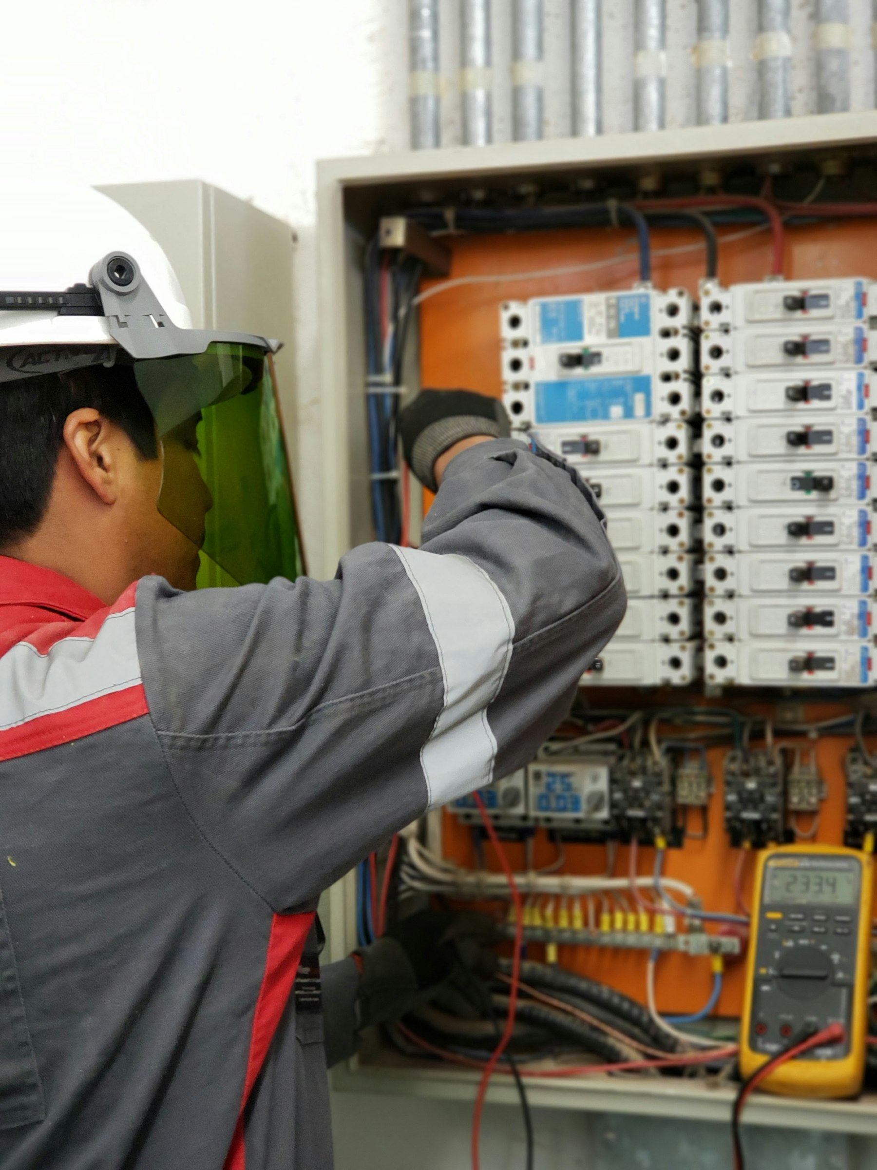 Licensed electrician testing an electrical panel before an EV charger installation