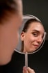 Woman admiring her face after acne treatment.