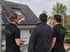 Drei Männer in schwarzen G&W Elektro-T-Shirts stehen auf einem Gerüst und betrachten Solarmodule auf einem Hausdach.