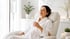 Woman relaxing with NAD IV therapy and a glass of water