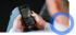 Hände halten ein Smartphone mit einer App, die Daten auf einem dunklen Bildschirm anzeigt.