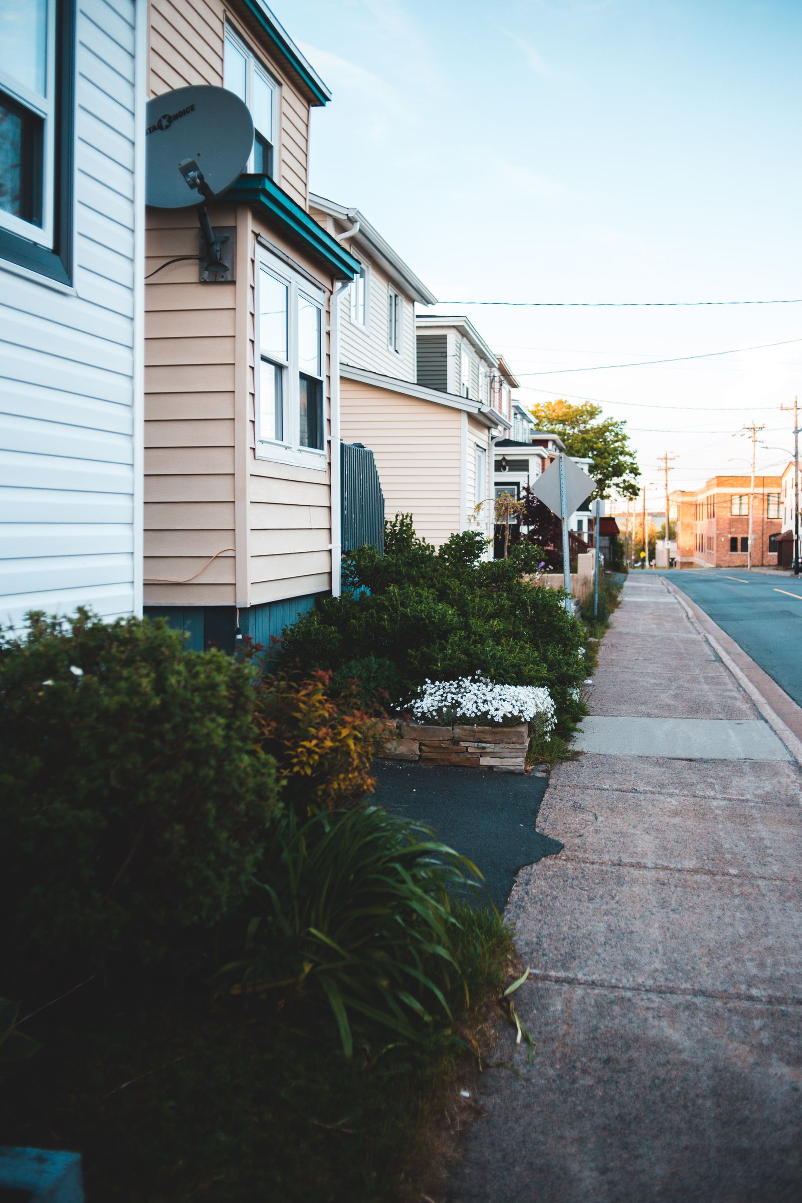 Residential street lined with single-family homes and pitched roofs