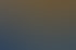 Ein lächelnder Mann im blauen Anzug unterhält sich bei einem Networking-Event mit anderen Teilnehmern.