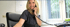 Freundliche Mitarbeiterin der Stahlbau Jakobs GmbH im Büro, lächelnd am Telefon