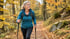 Frau beim Walking mit Stöcken auf einem herbstlichen Waldweg (Symbolbild, KI-generiert)