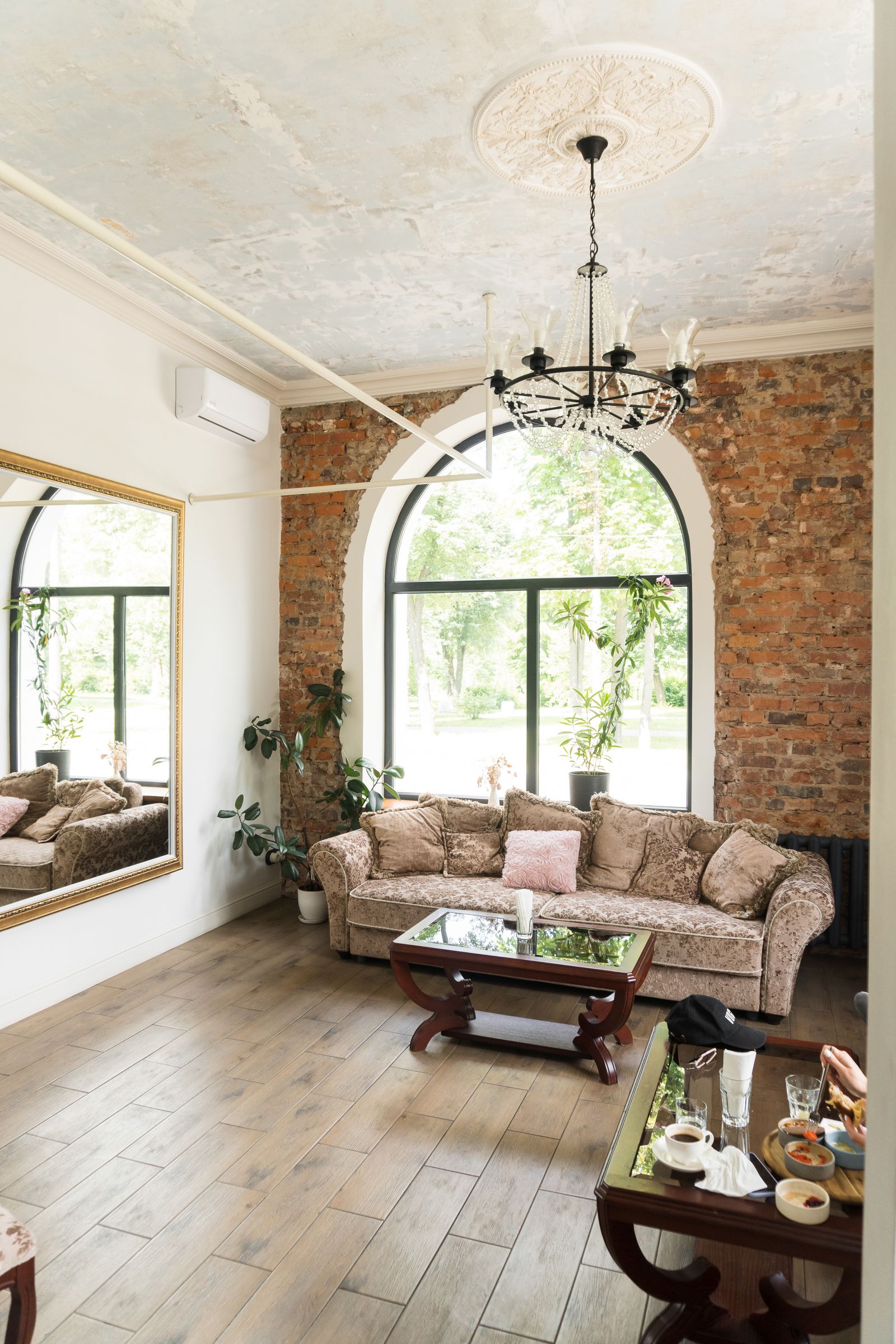 Room with tall arched windows looking out onto trees