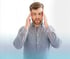 Man with a headache holding his temples.
