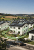 Siedlung von Häusern mit Solarmodulen auf Dächern, grünen Lichtströmen und einem Auto auf der Straße.