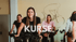 Mehrere Personen beim Spinning-Kurs im Fitnessstudio, eine junge Frau lächelt in die Kamera. Text: KURSE