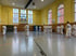 Karate-Training in einer Sporthalle mit mehreren Personen in weißen Gis.
