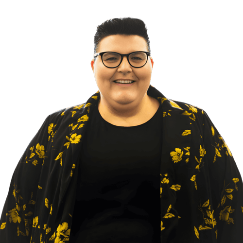 Laughing person with a black T-shirt, black jacket with yellow flowers and glasses.