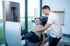 Ein Physiotherapeut unterstützt einen älteren Mann beim Training an einer Beinpresse der Marke Frei.