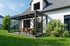 Modernes Haus mit großem Glaswintergarten, Terrasse und Garten.