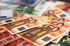 Ein Stapel verschiedener Euro-Geldscheine, wobei mehrere orangefarbene 50-Euro-Noten im Vordergrund liegen.