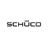 Schwarzes SCHÜCO-Logo mit zwei Kronenzacken über dem Ü auf dunkelgrünem Hintergrund.